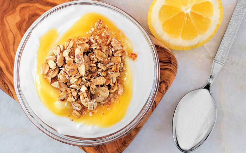 bowl of yogurt with granola and lemon