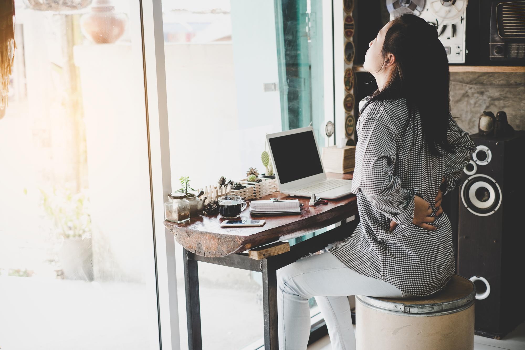 sitting woman holding back in discomfort